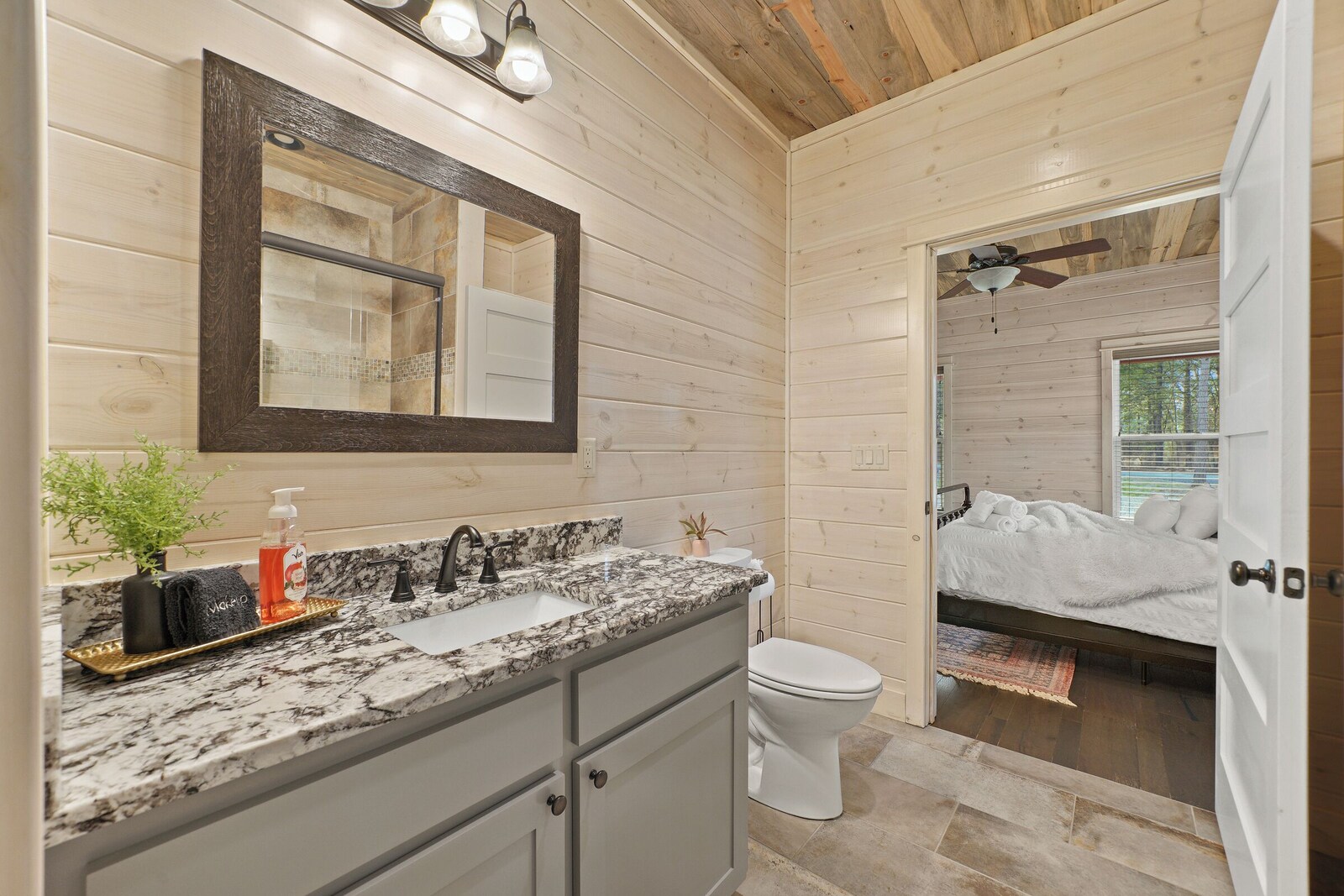 Bathroom with wooden interior, marble sink, and large mirror