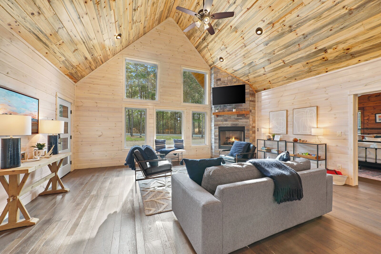 Log cabin living area with fireplace, sofa, and dining space
