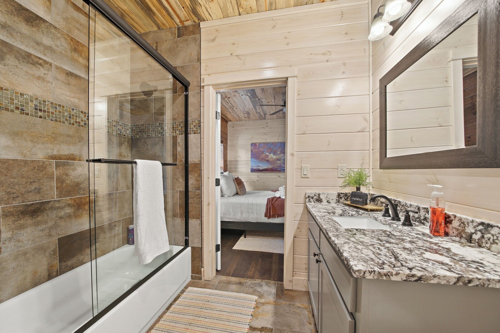 Ensuite bathroom with glass shower enclosure and marble countertop