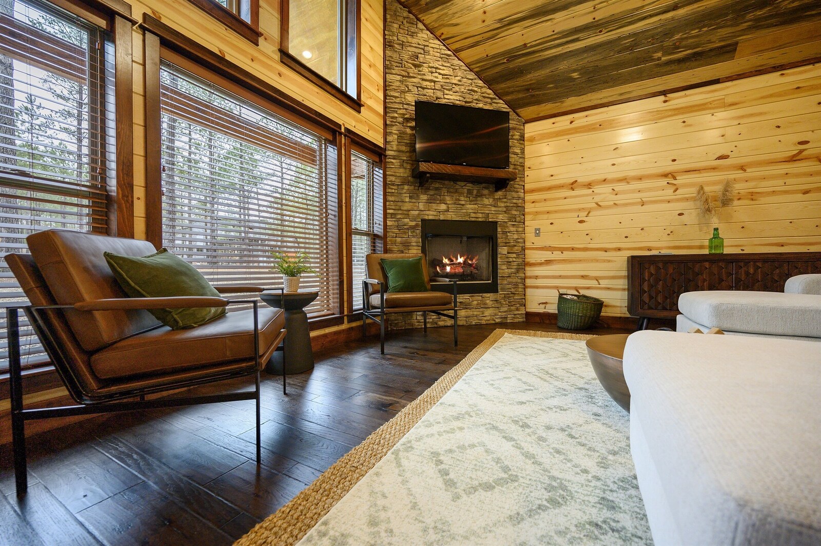 Emerald Escape living room with stone fireplace and forest views