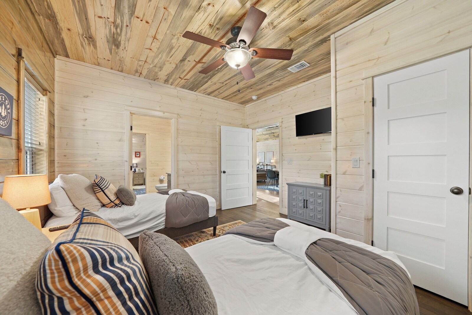 Spacious bedroom with sofa, desk, and ceiling fan