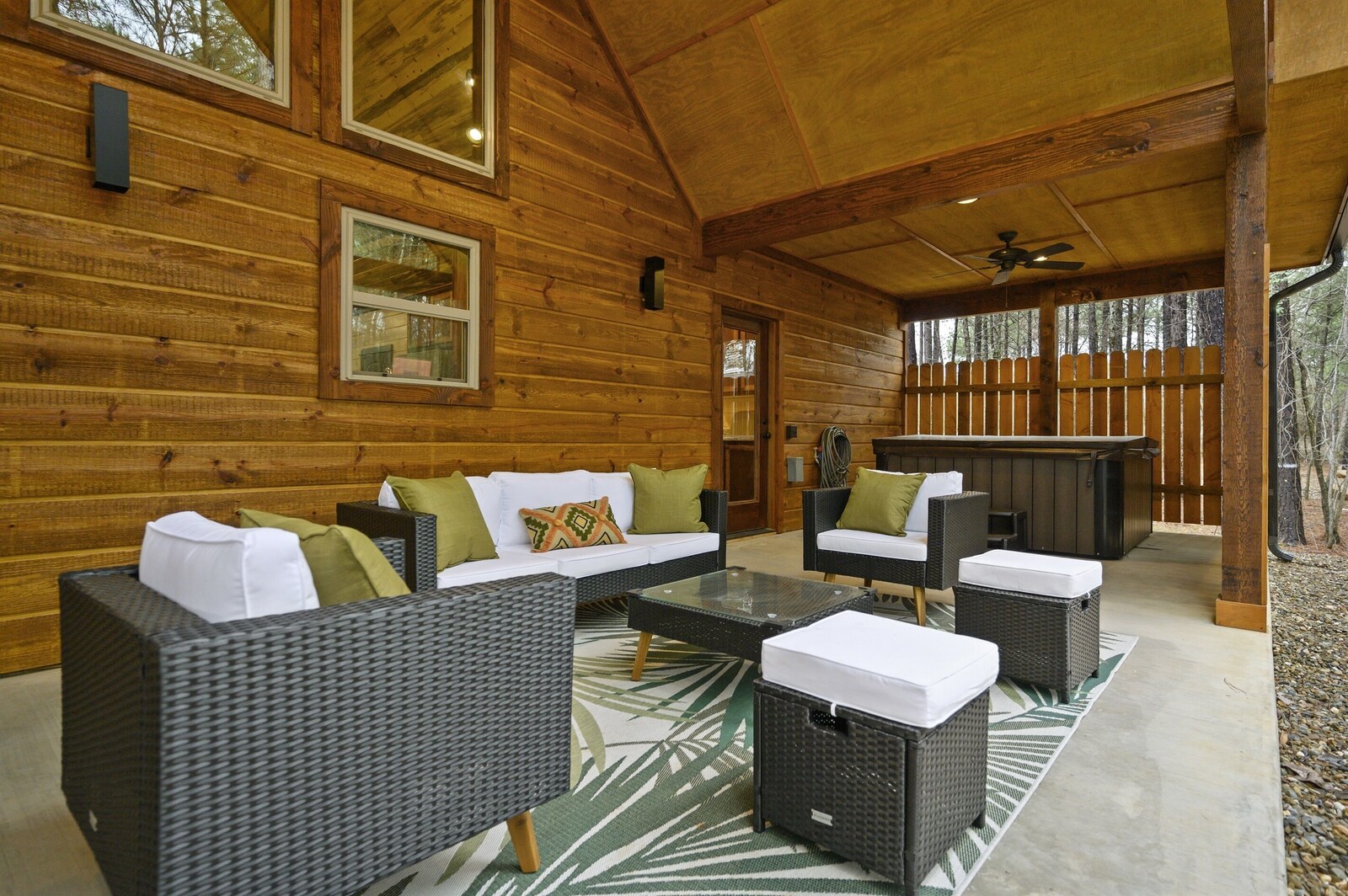 Covered patio seating beside the Emerald Escape hot tub