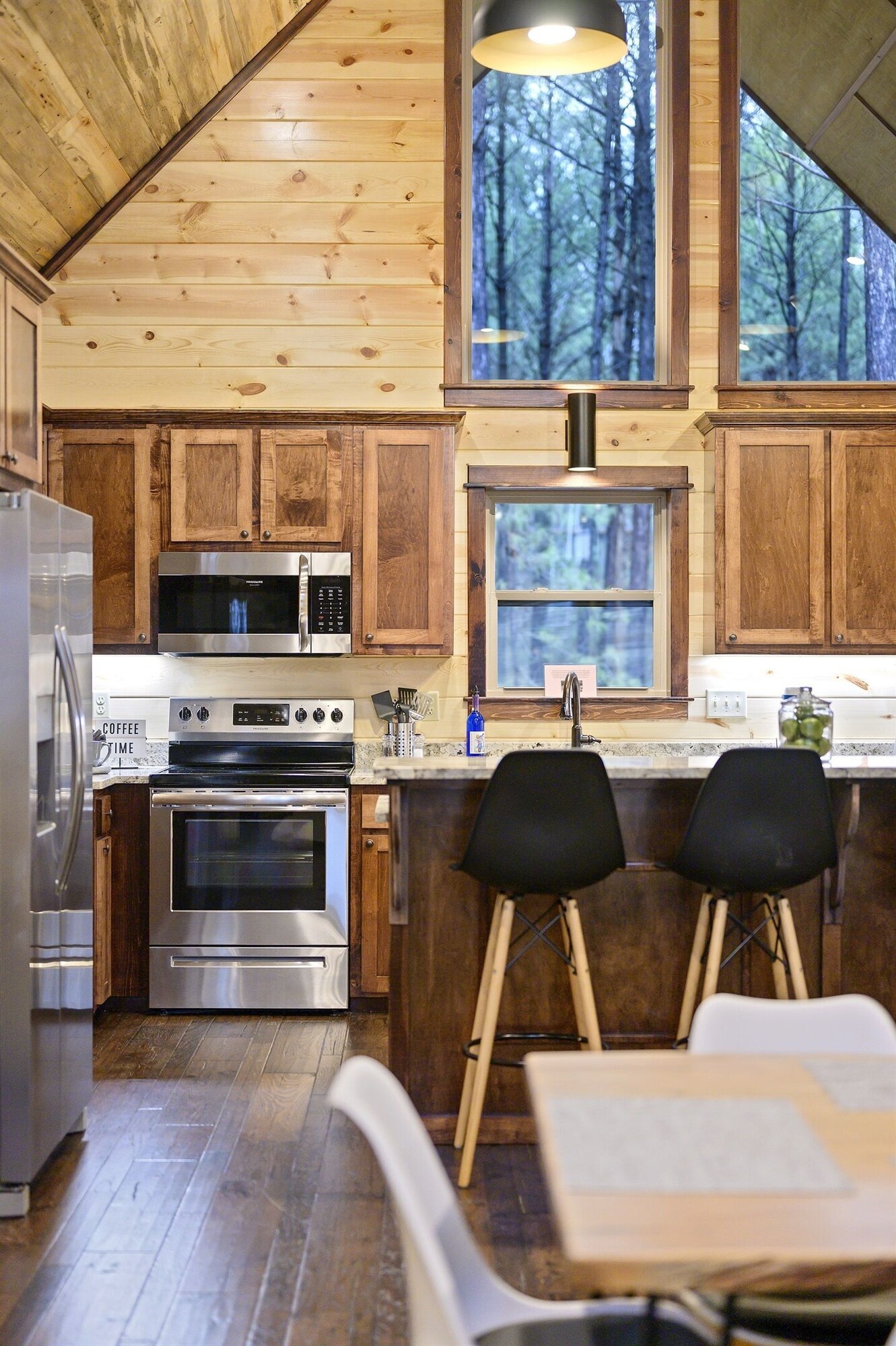 Emerald Escape kitchen with wood cabinets and forest-view window