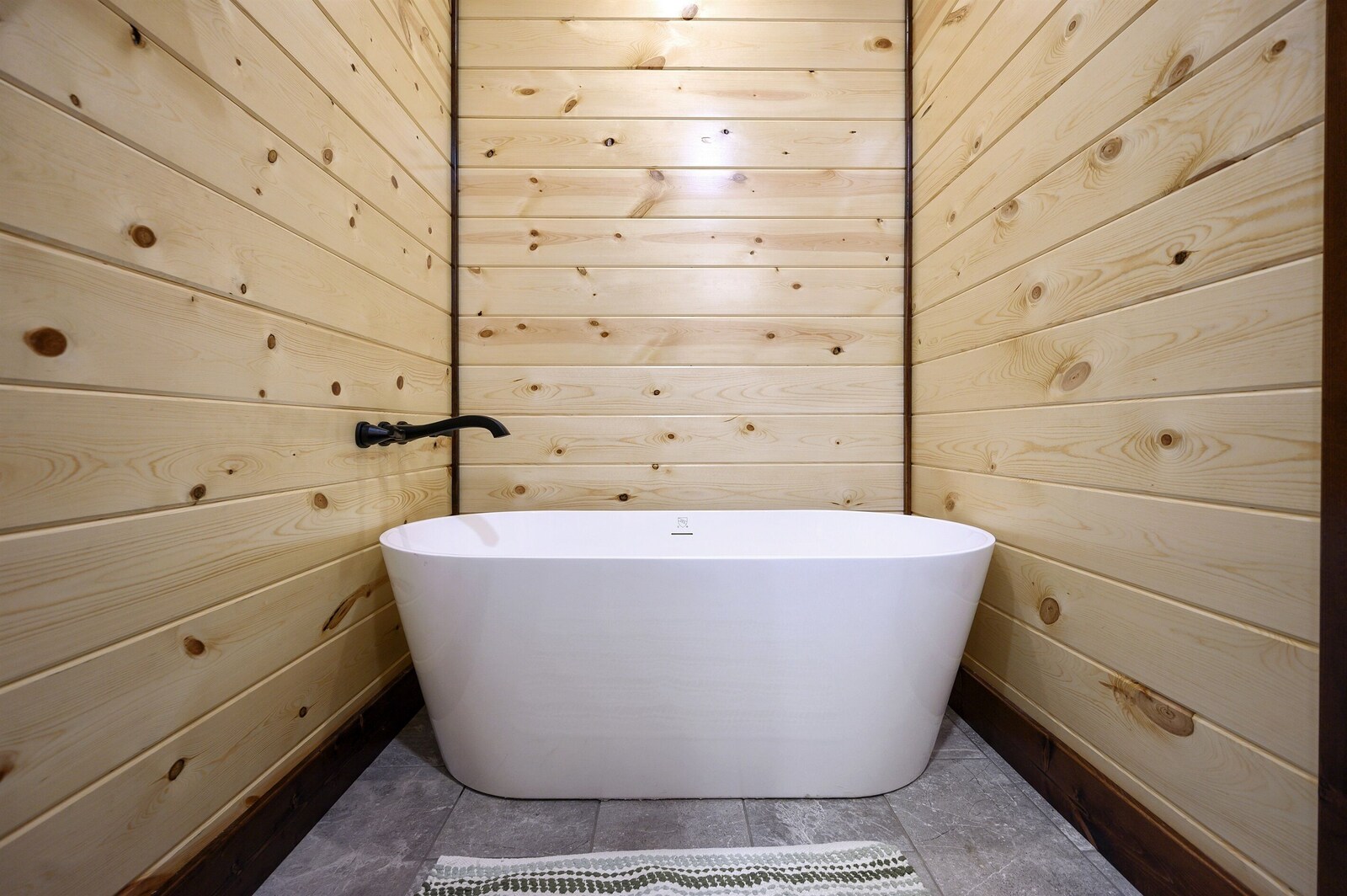 Emerald Escape freestanding soaking tub in wood-panel nook