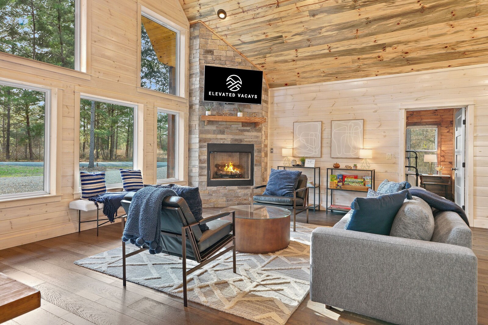 Living room with fireplace, large windows, and cozy seating