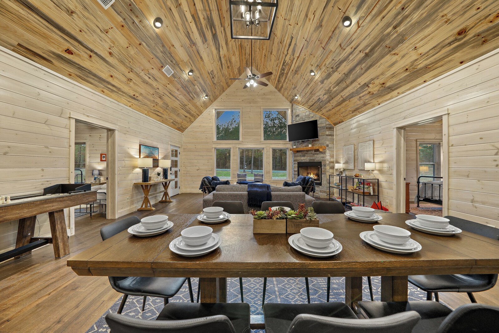 Dining area with a wooden table set for six beside the fireplace