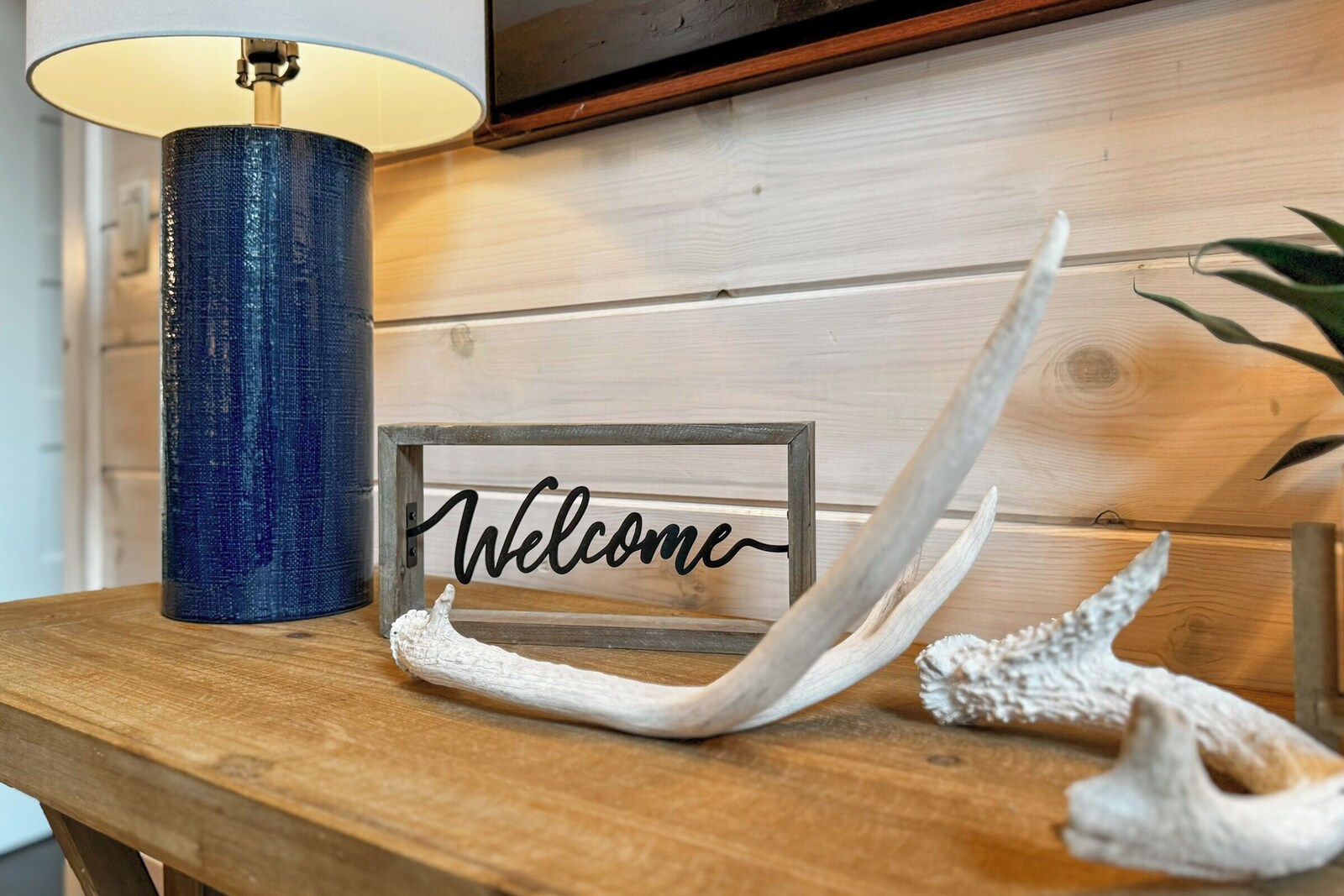Entry table with a blue lamp and a Welcome sign