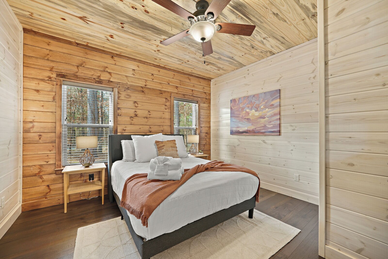 Bedroom with white bedding, blinds, and framed artwork