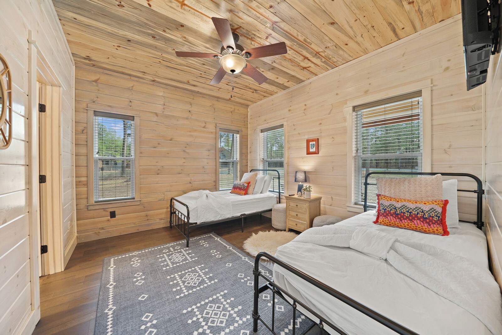 Cabin-style bedroom with two beds and large windows
