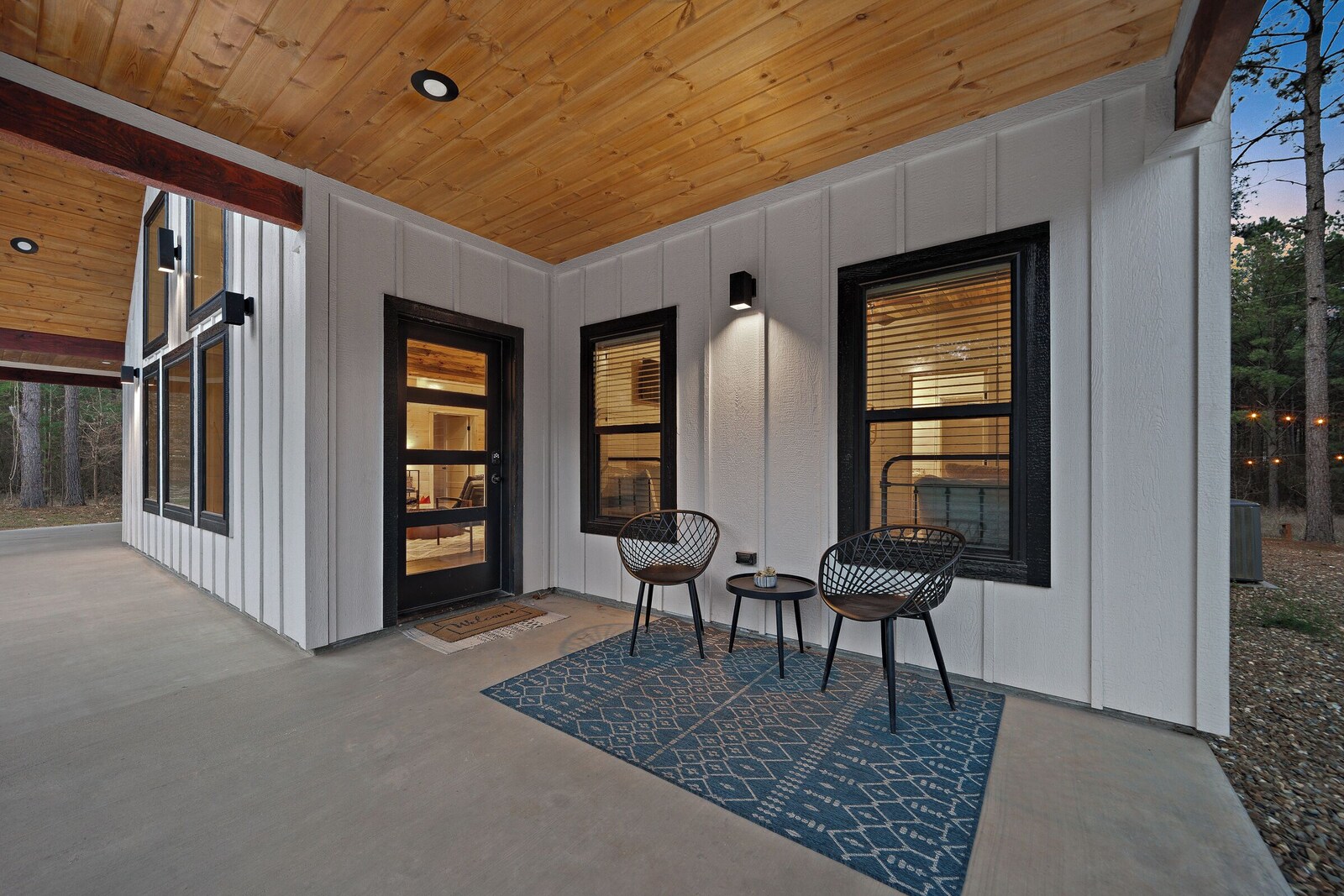 Covered porch with two chairs and a small table