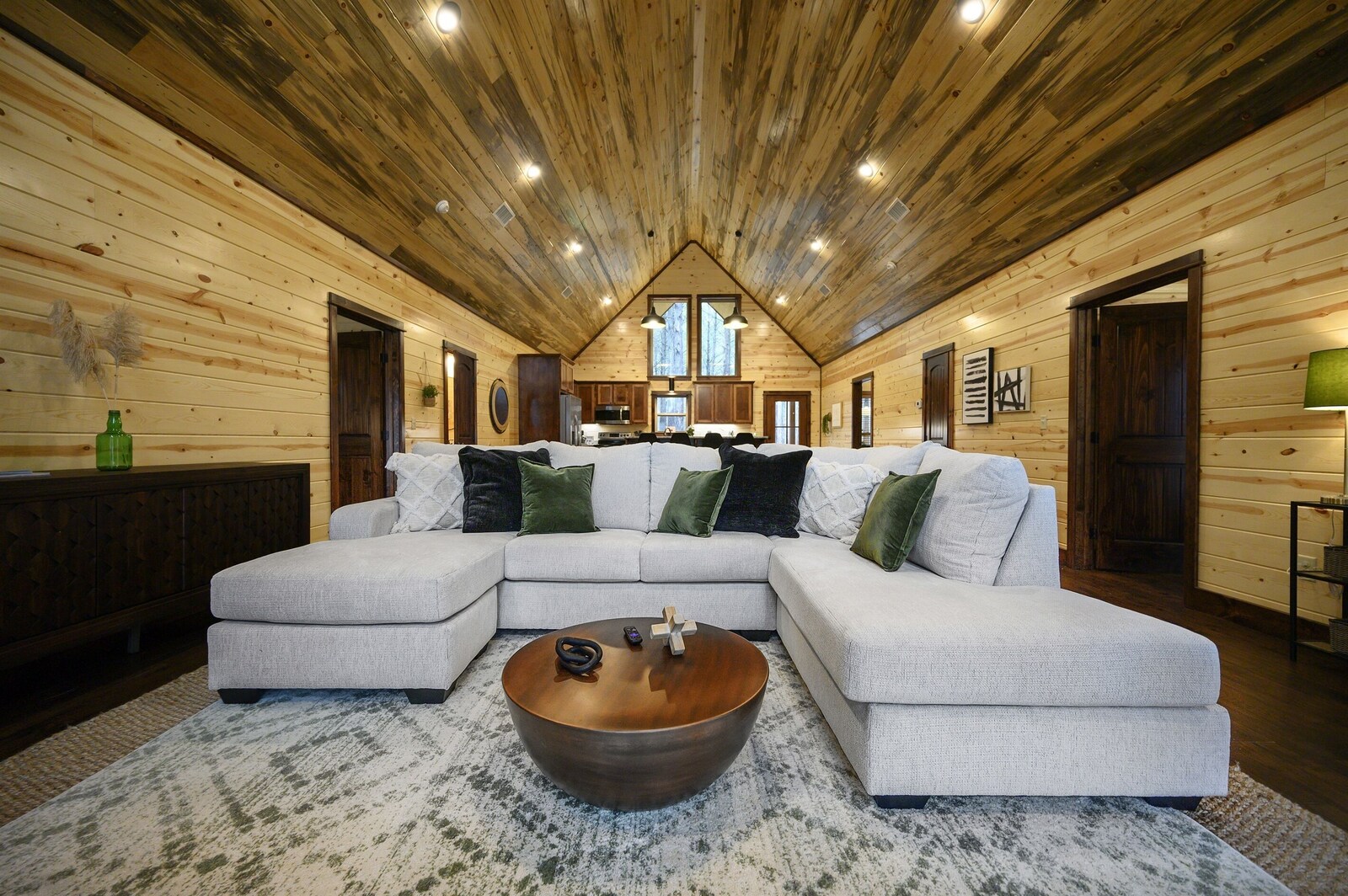 Emerald Escape great room with L-shaped sectional and beamed ceiling