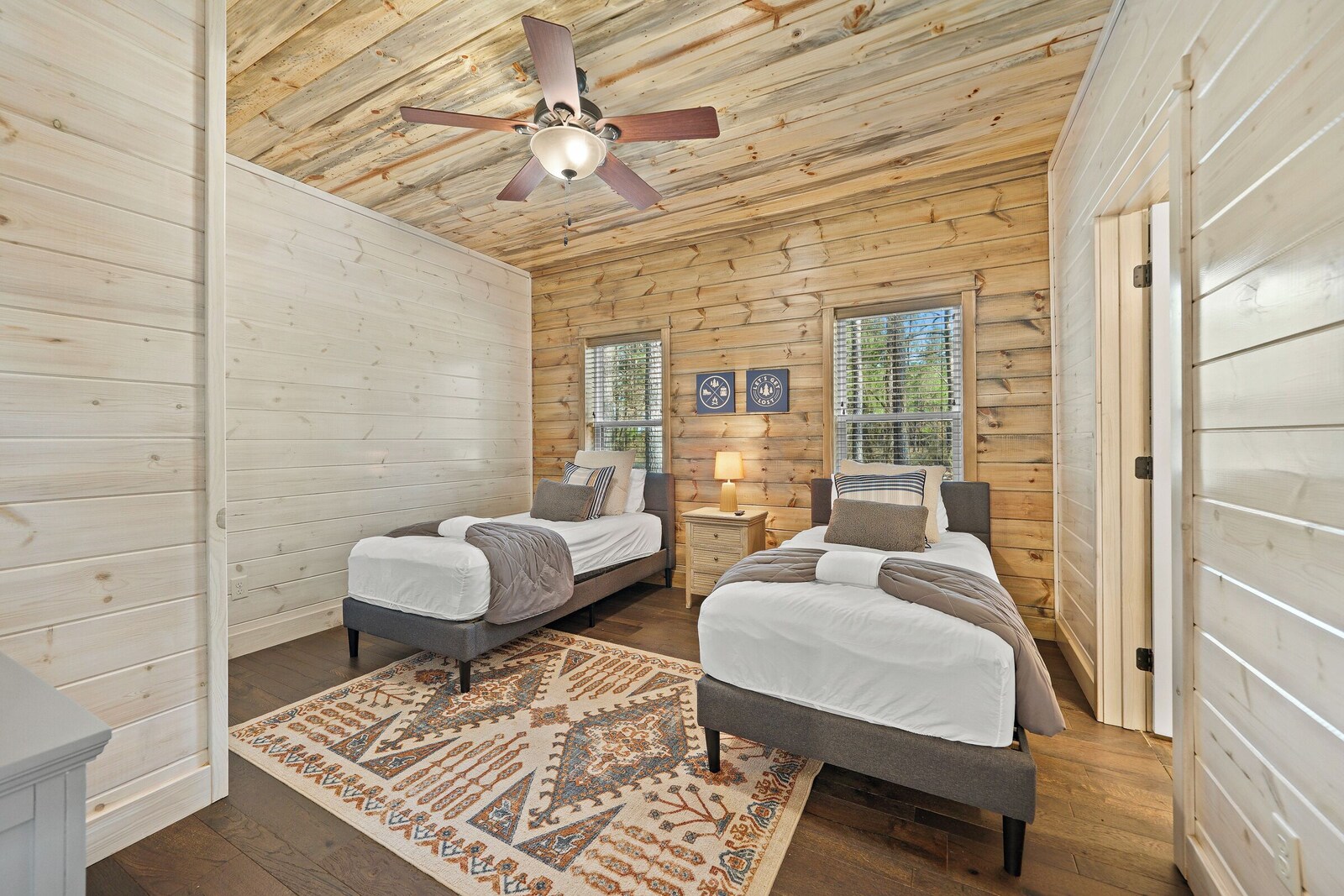 Twin bedroom with two beds, ceiling fan, and patterned rug