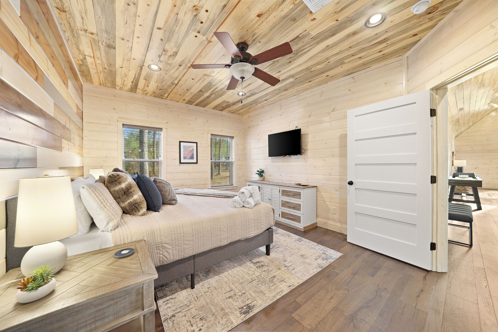 Bedroom with queen bed, bedside lamp, and ceiling fan